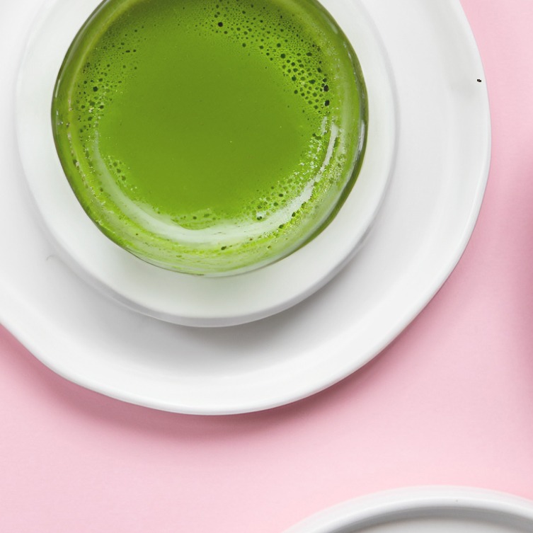 A bowl of vibrant green matcha on porcelain.