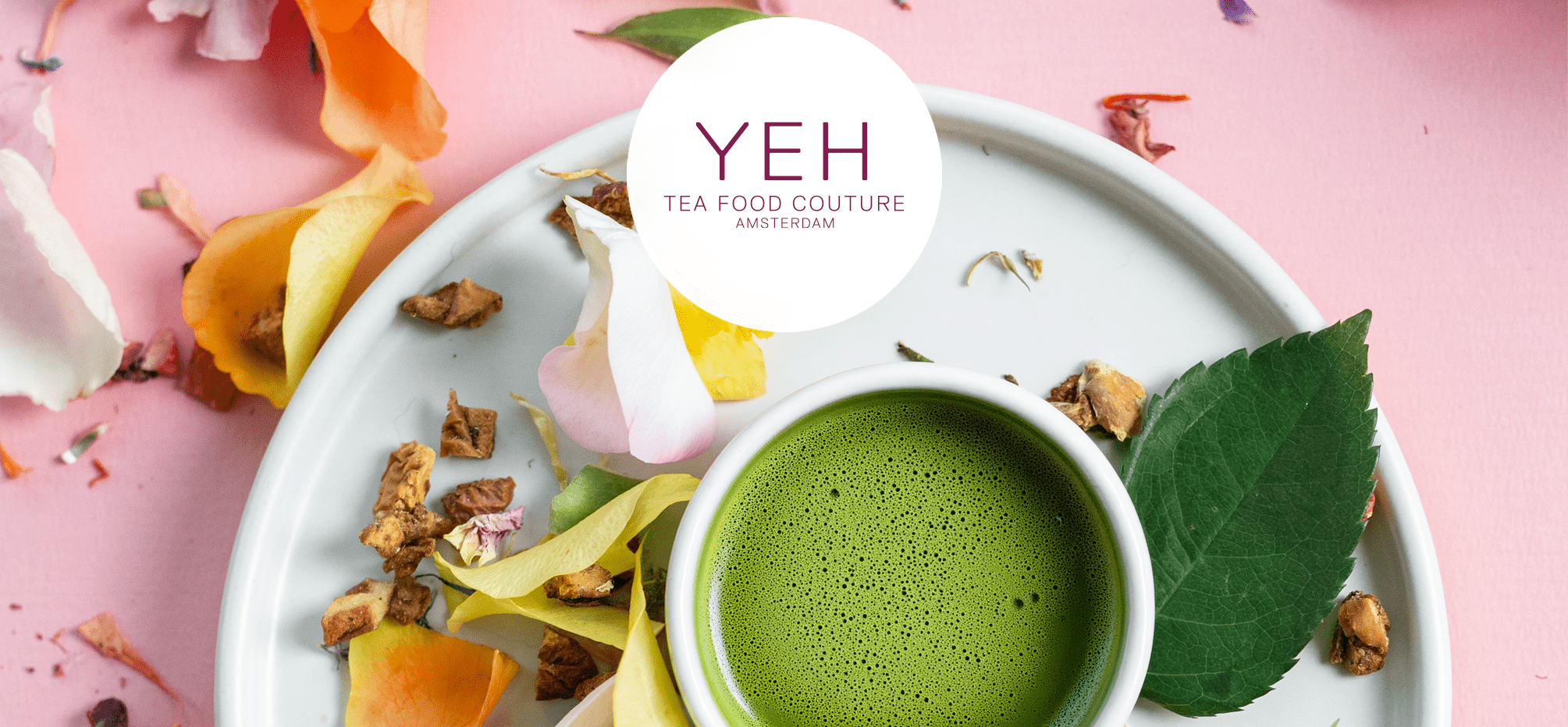Bowl of vivid green matcha powder among rose petals.